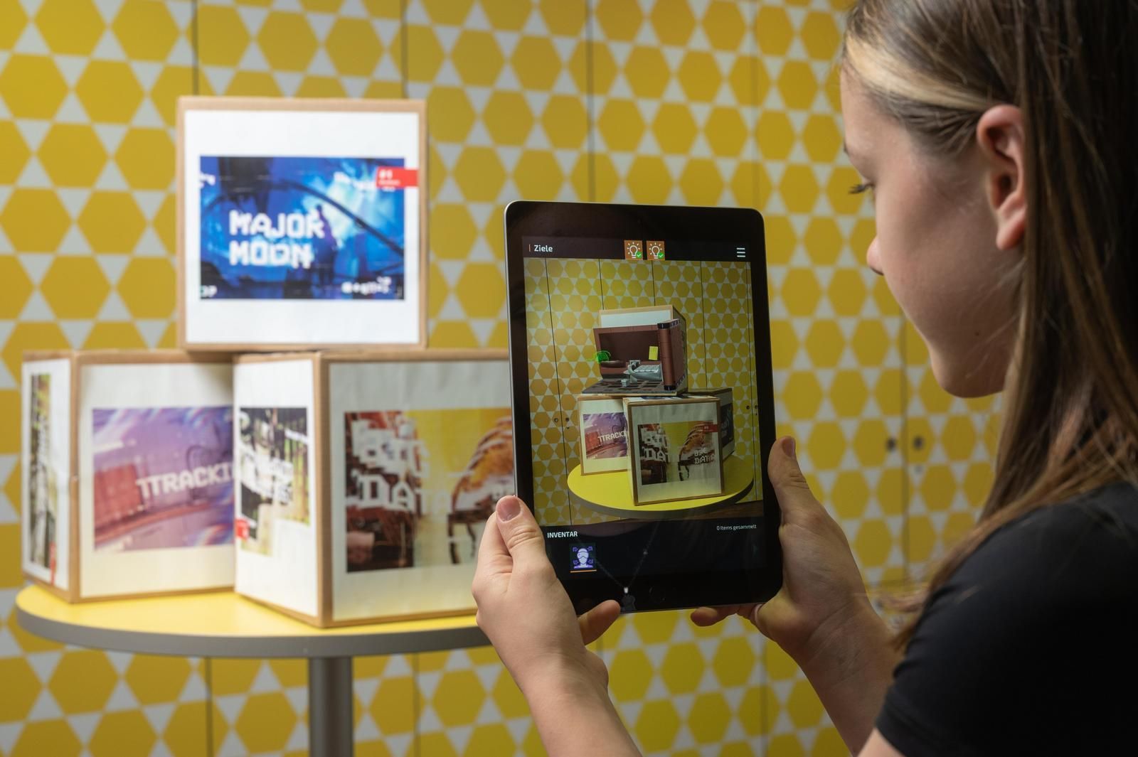 Major Moon Screenshot einer Nutzerin mit Tablet beim Fotografieren einzelner Bilder des  Makersets